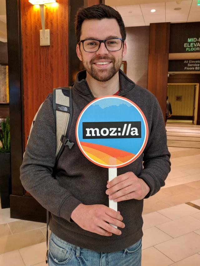 Me holding a sign with the Mozilla logo on it